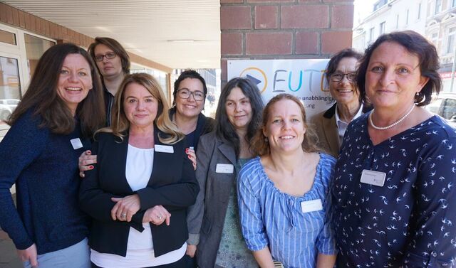Mitarbeiterteam der Beratungsstelle. Dieses besteht aus acht Frauen, die in die Kamera lächeln und vor einem Vordach eines Gebäudes stehen.